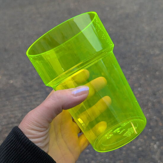 200-2NYC Yellow UV Plastic Pint Glass - In Hand Yellow UV Plastic Pint Glass